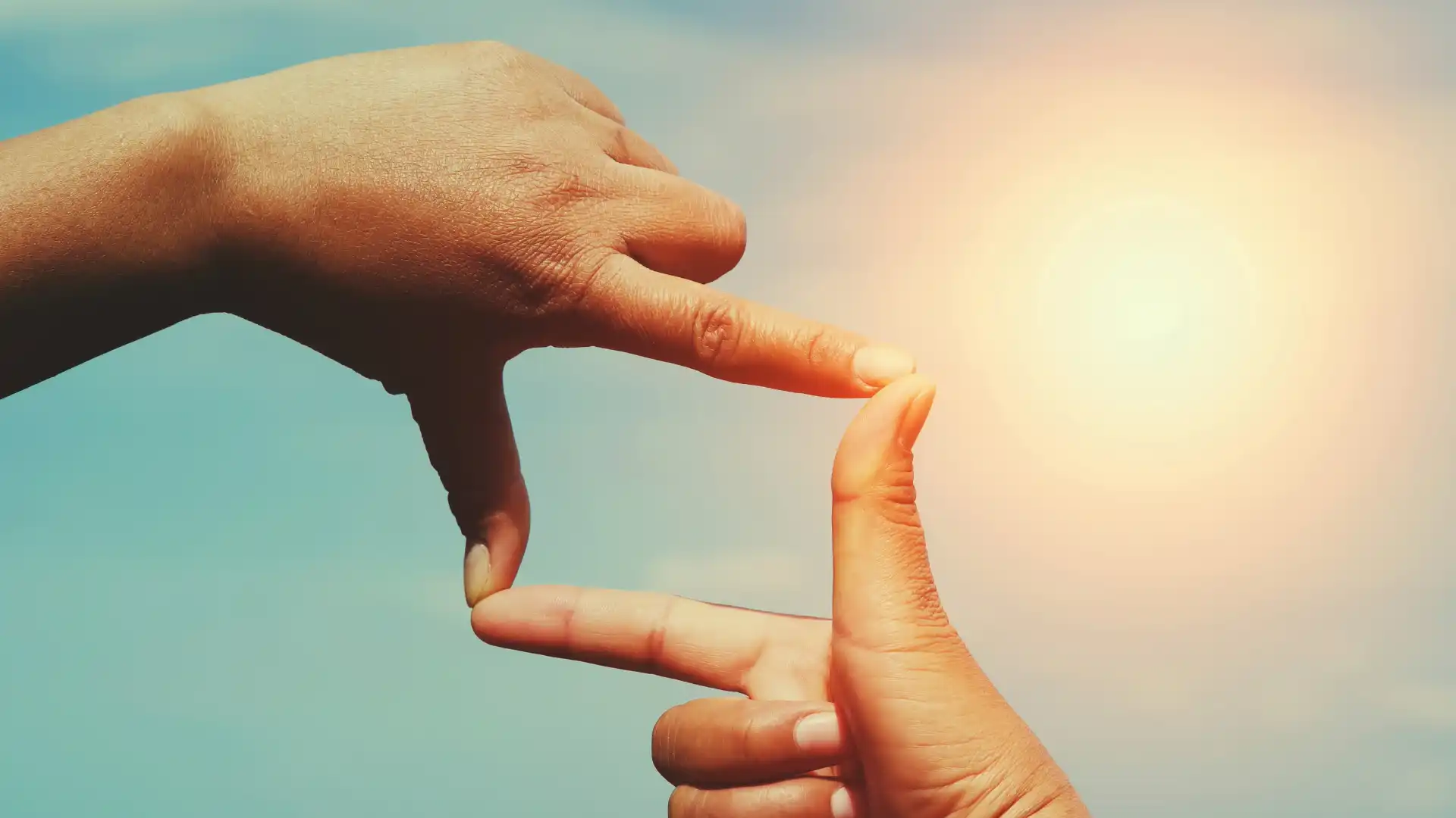 両手の指で四角を作り太陽をフォーカスしている