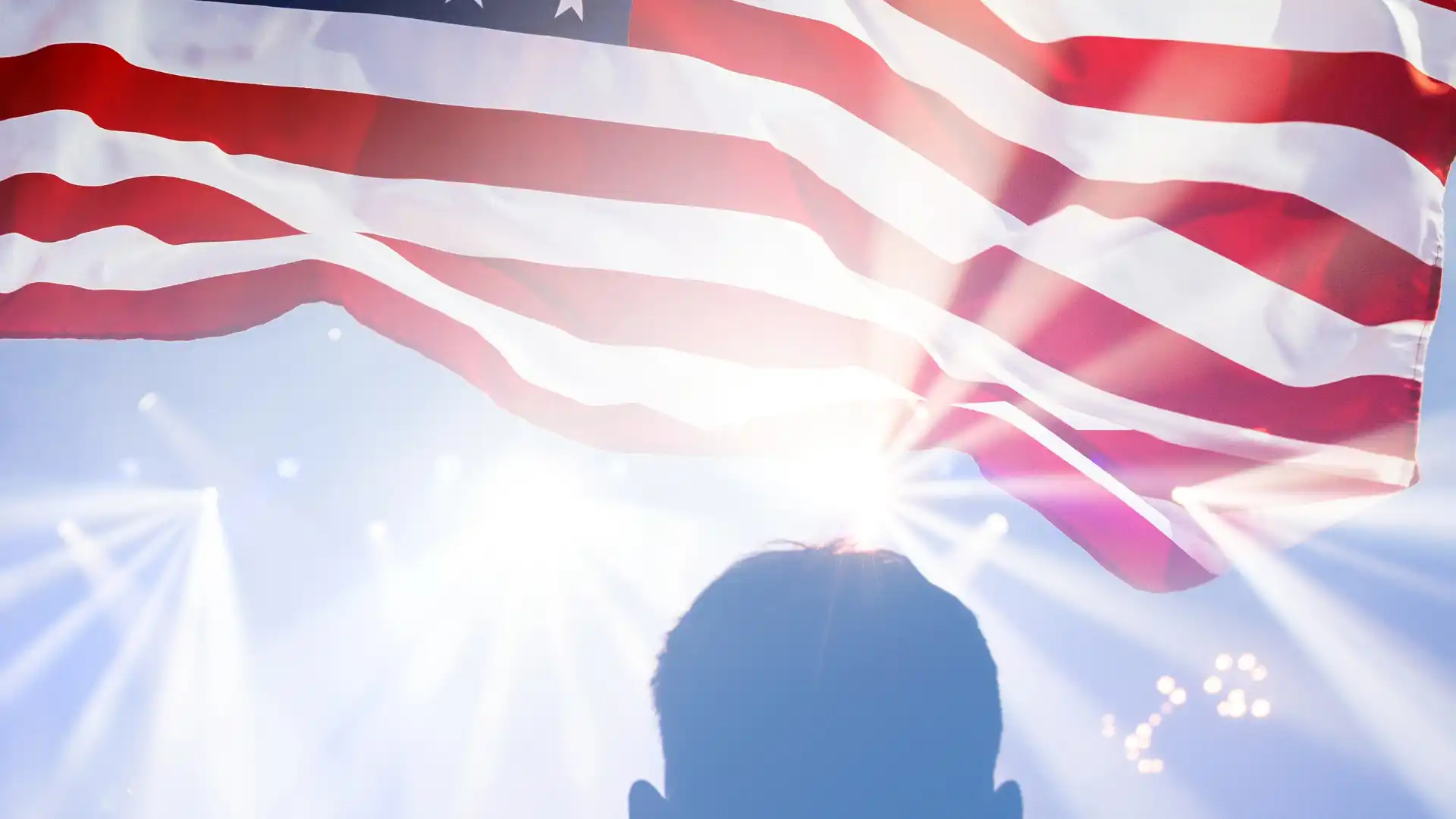 アメリカ国旗を光が透過して男性に降り注いでいる
