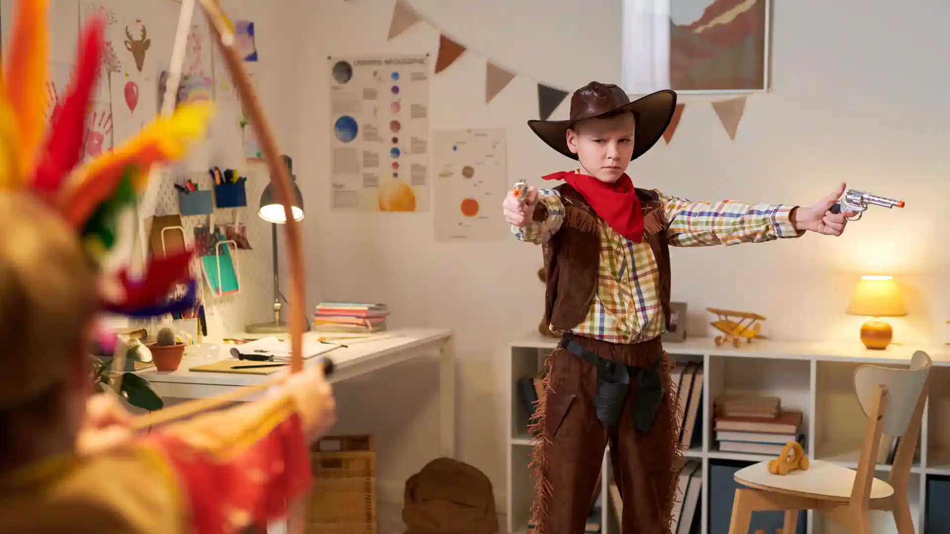 カウボーイの格好をして遊んでいる少年が鉄砲を構えている