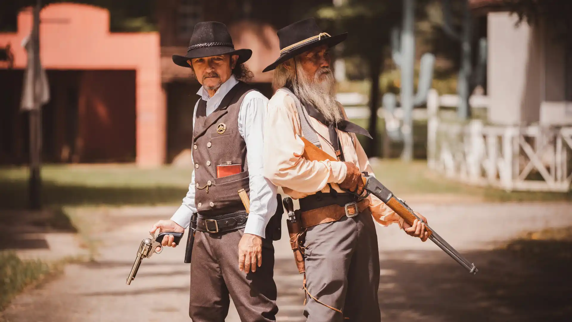 西部劇の一場面で2人の男が並んで銃を持って立っている