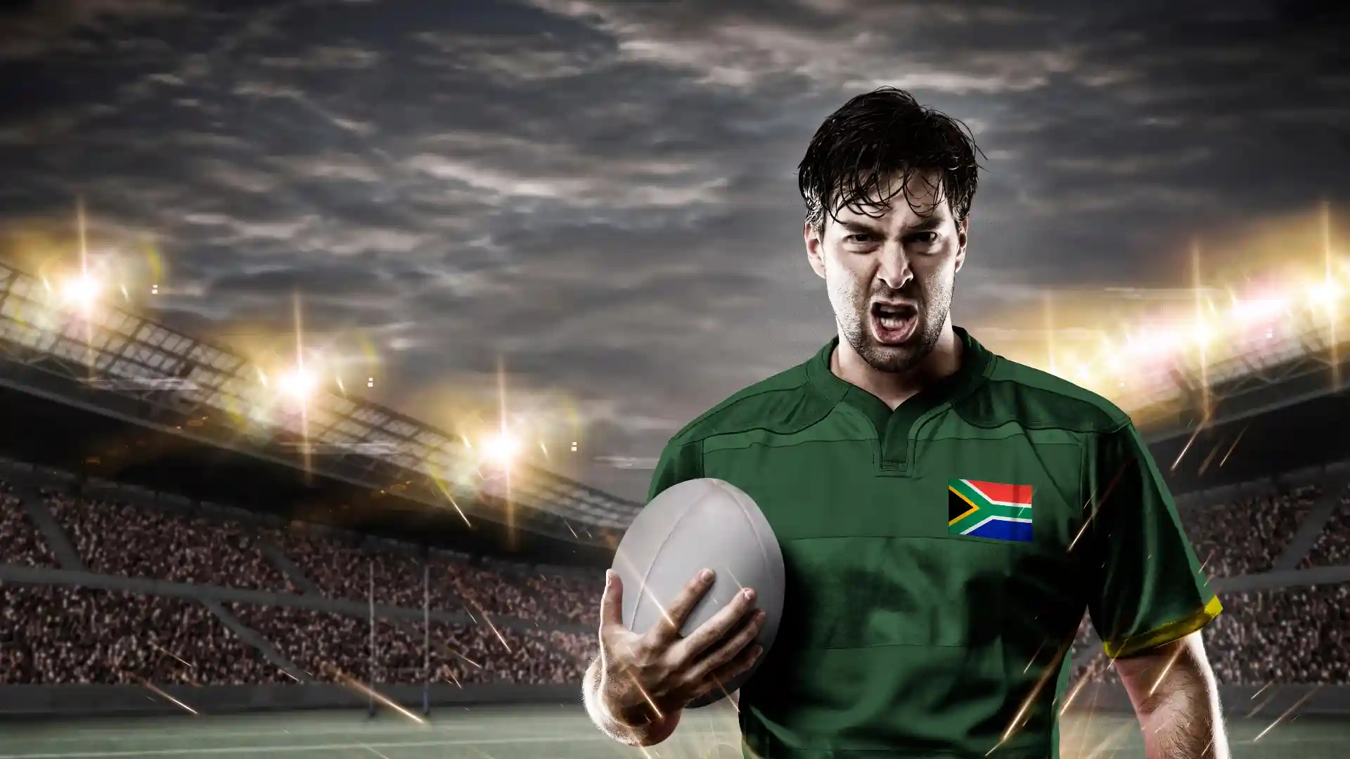 ラグビー場でラグビー選手がボールを片手にもち投資むき出しの表情でこちらを見ている